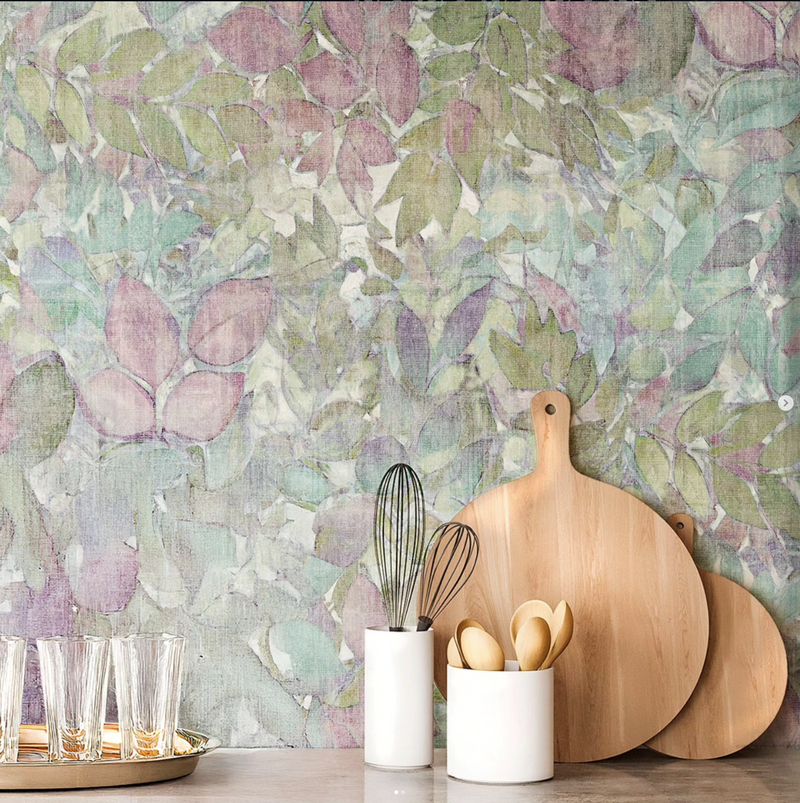 Kitchen setting with wooden cutting boards and utensils against a leafy green wallpaper.
